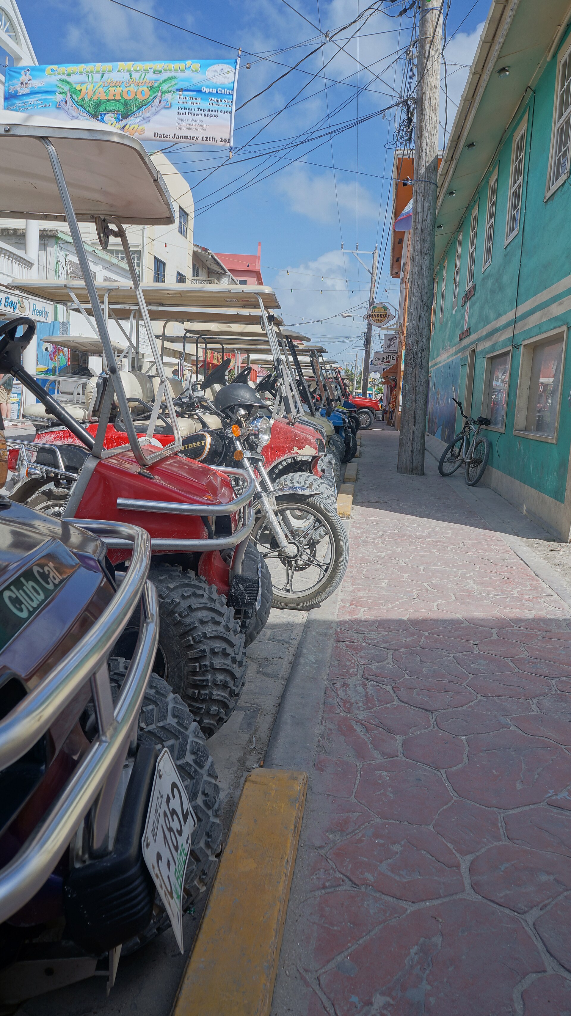 Golf carts lining a colorful street in San Pedro, Belize