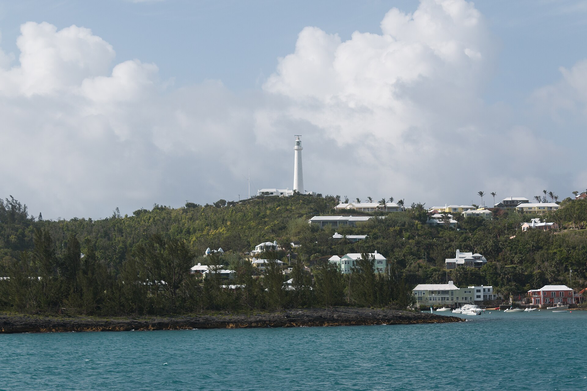 Gibbs Hill Lighthouse rising above green hills and blue water in Bermuda