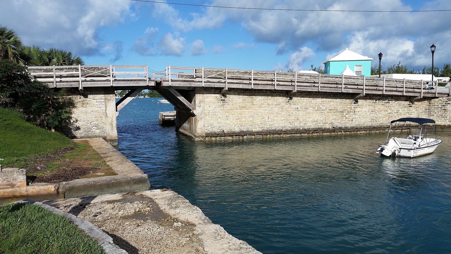 Somerset Drawbridge spanning blue water beside a white-roofed Bermuda home