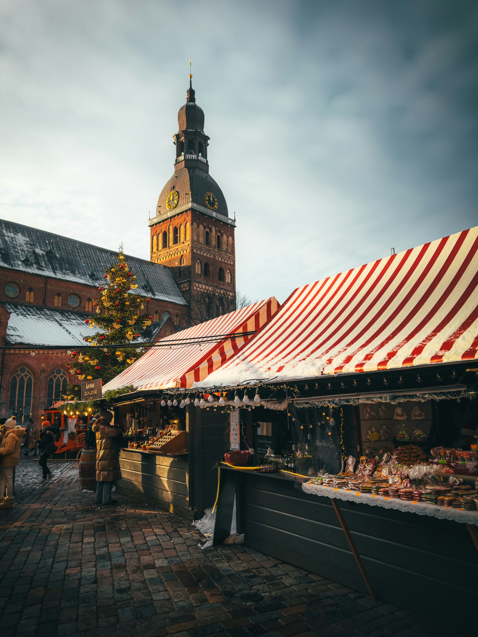 Snow-dusted red and white Christmas market stalls and decorated tree in Riga, Latvia
