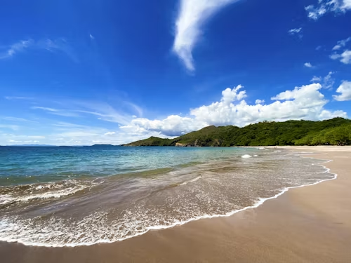 Sandy Pacific beach and green coastal headlands in Guanacaste, Costa Rica