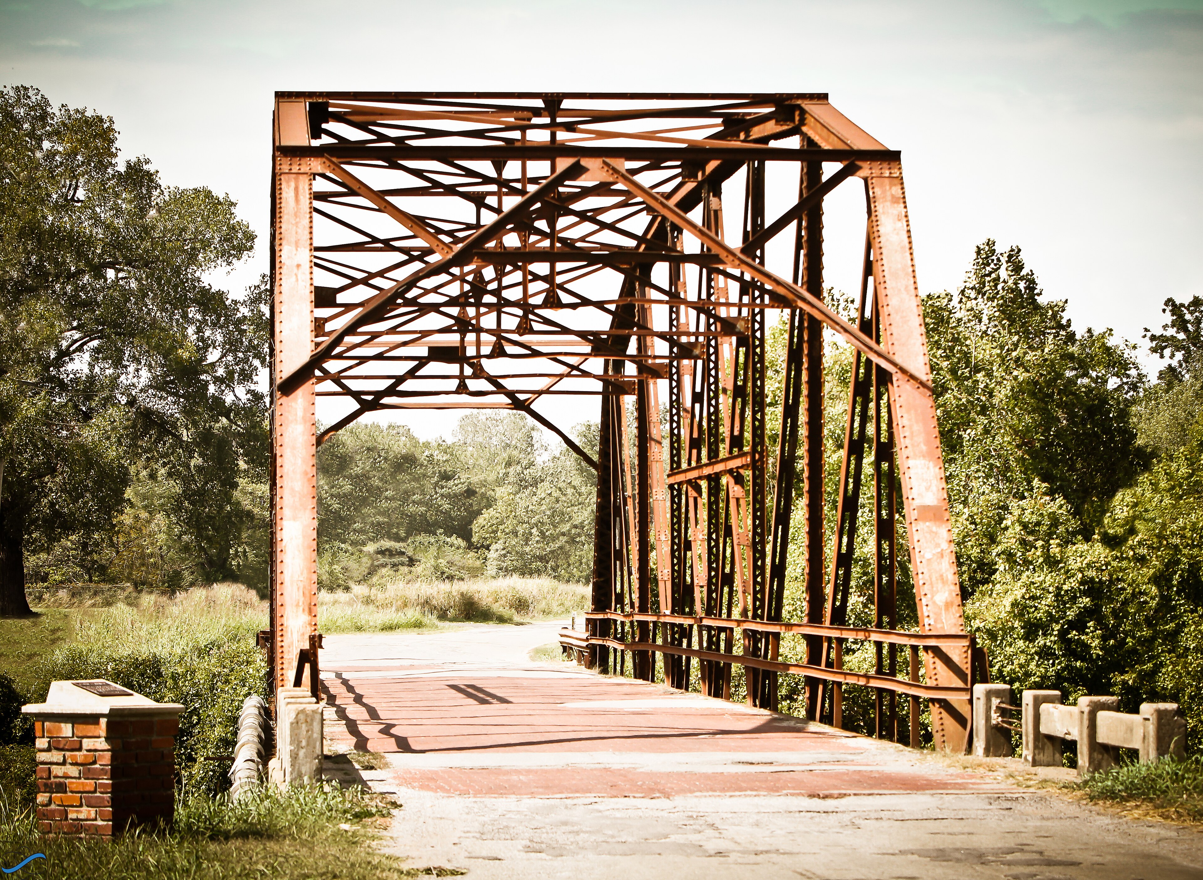 A narrow preserved iron bridge carries an old Route 66 alignment through Oklahoma woodland