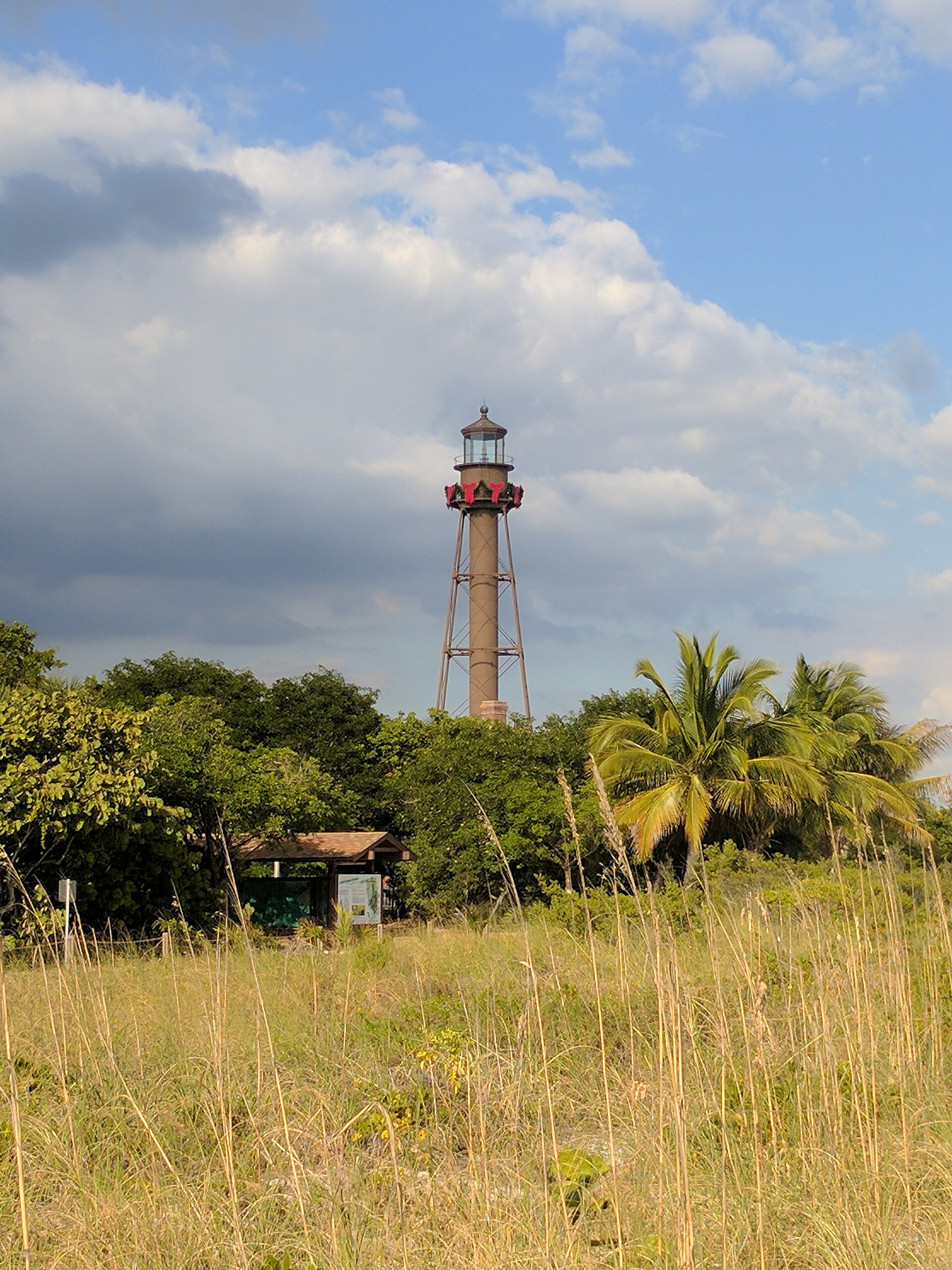 Sanibel Lighthouse rising above coastal vegetation and palms on the Gulf Coast
