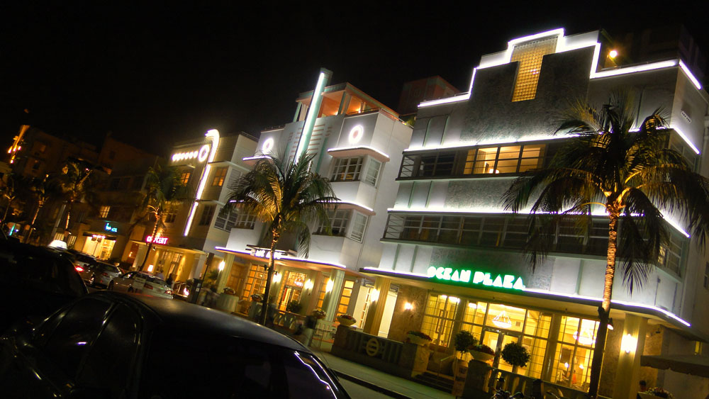 Neon-trimmed Art Deco hotels glowing at night on Miami Beach's Ocean Drive