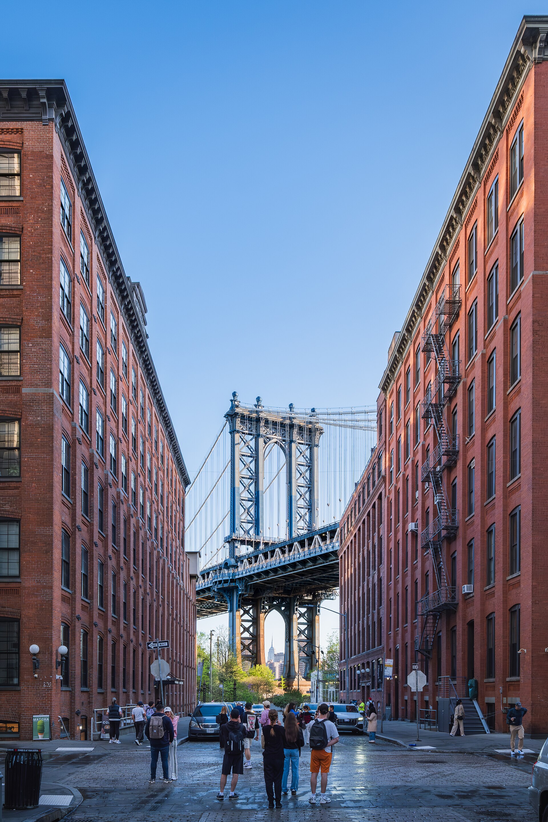 Manhattan Bridge framed by brick warehouses on Washington Street in DUMBO