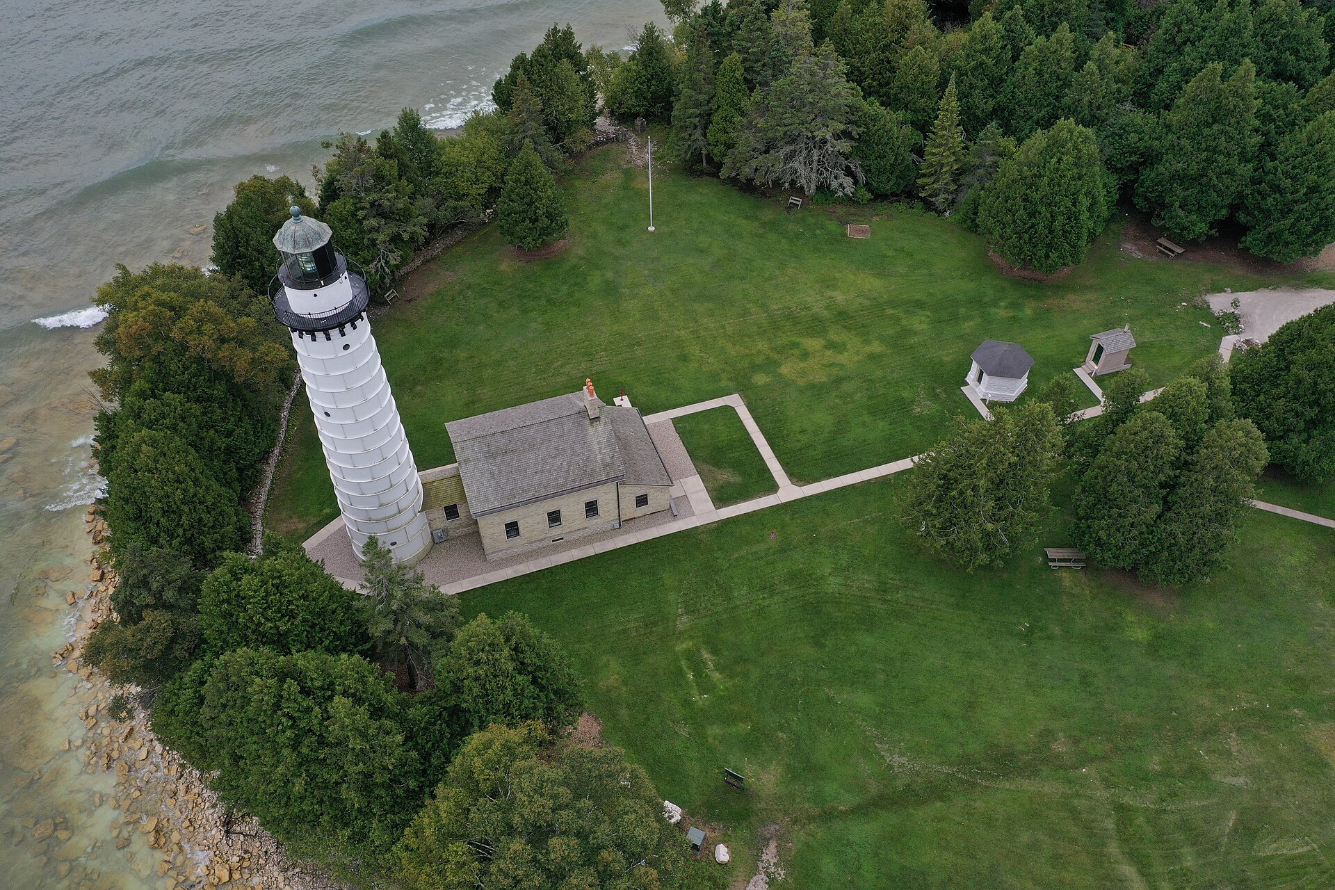 Cana Island Lighthouse stands on a wooded Door County shore surrounded by Lake Michigan
