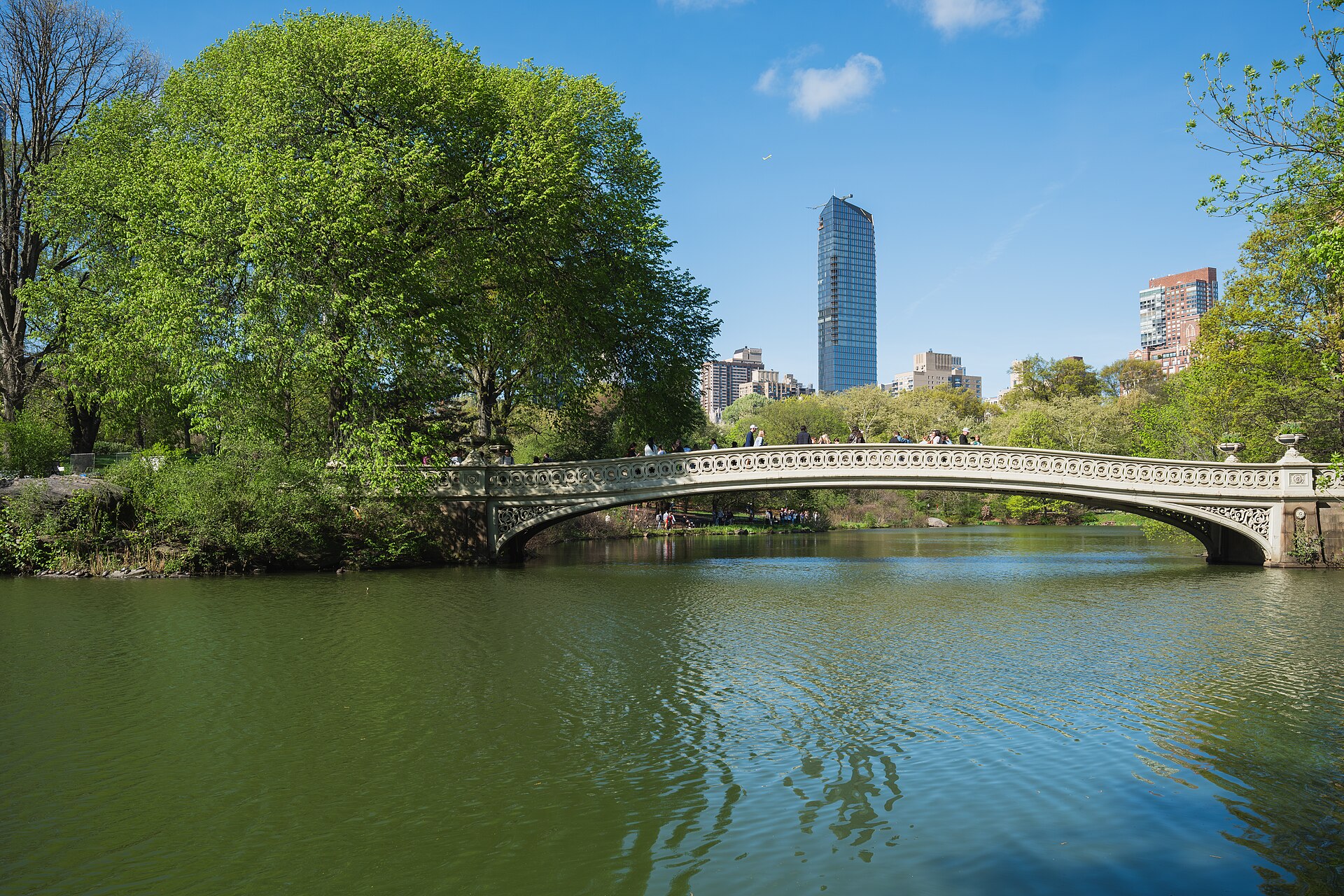 Bow Bridge crossing the lake beneath autumn trees and the Central Park South skyline