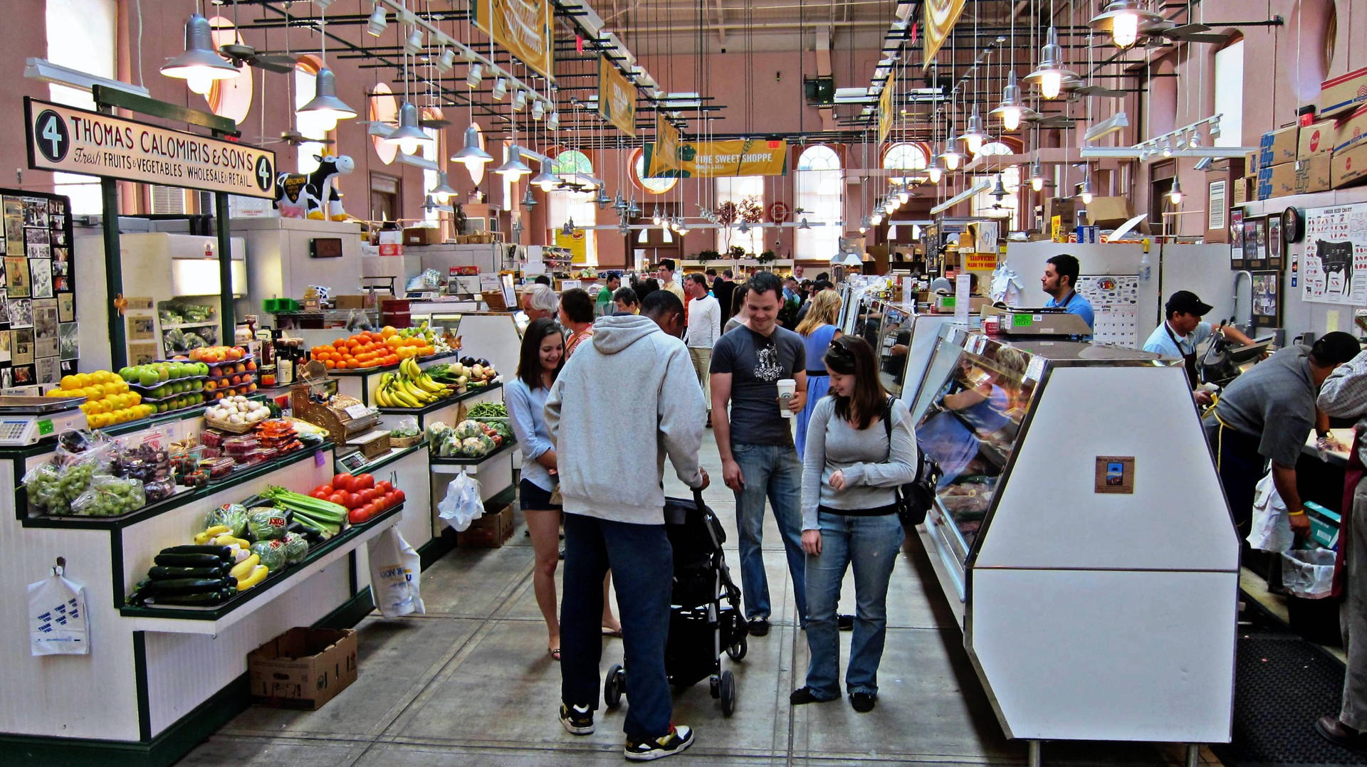 Shoppers moving among produce and food stalls inside Washington's Eastern Market