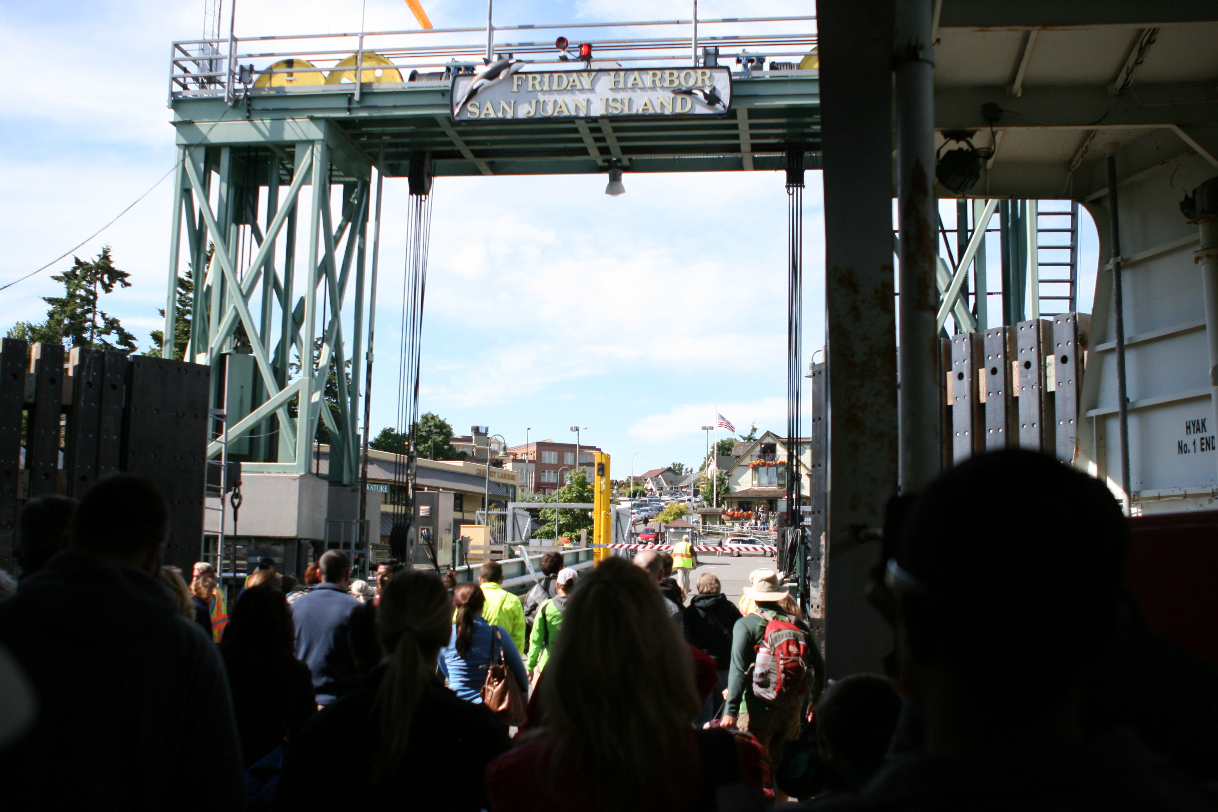 Ferry passengers arriving beneath the Friday Harbor San Juan Island landing sign