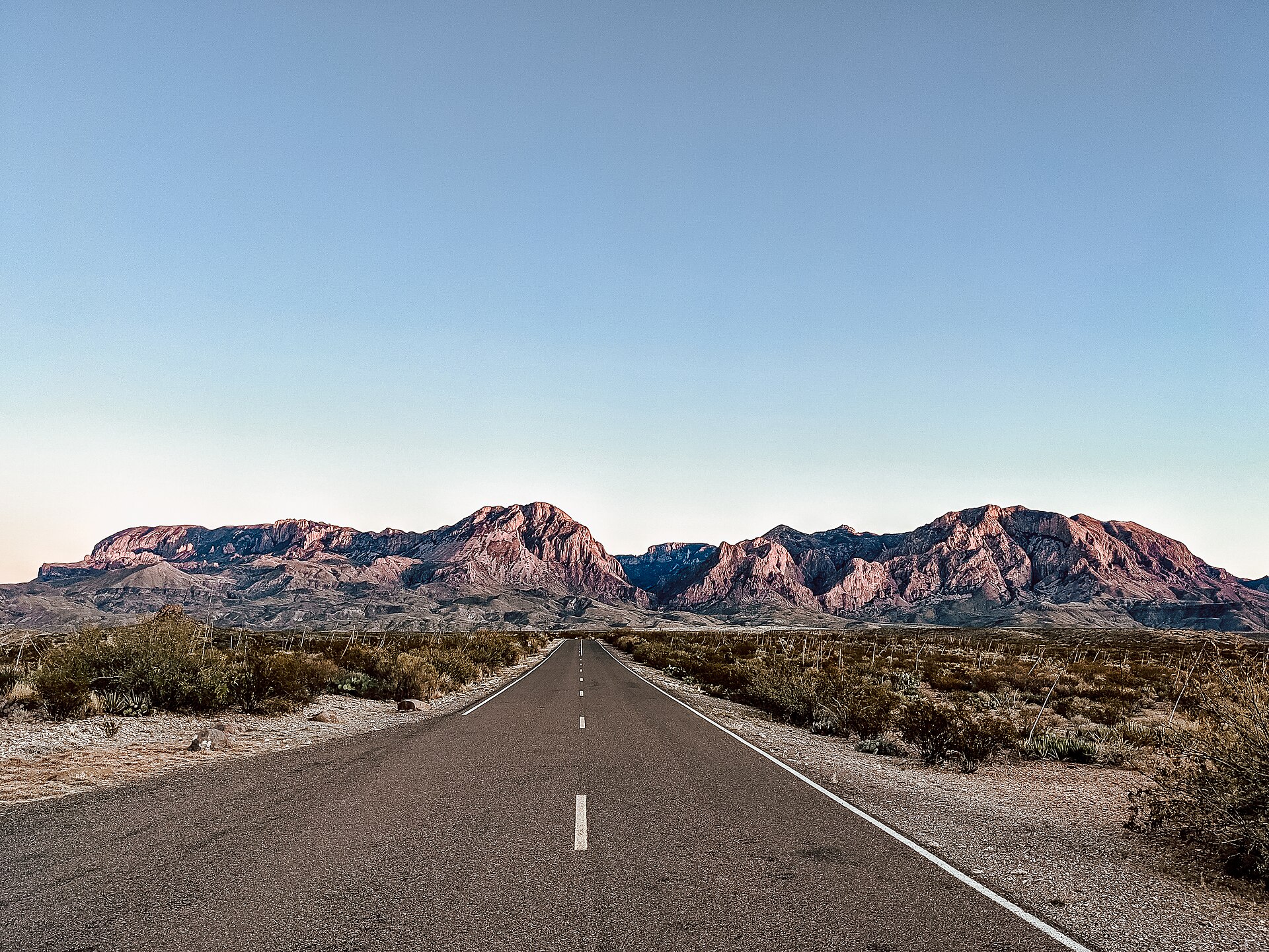 A desert road approaches the Chisos Mountains in Big Bend National Park