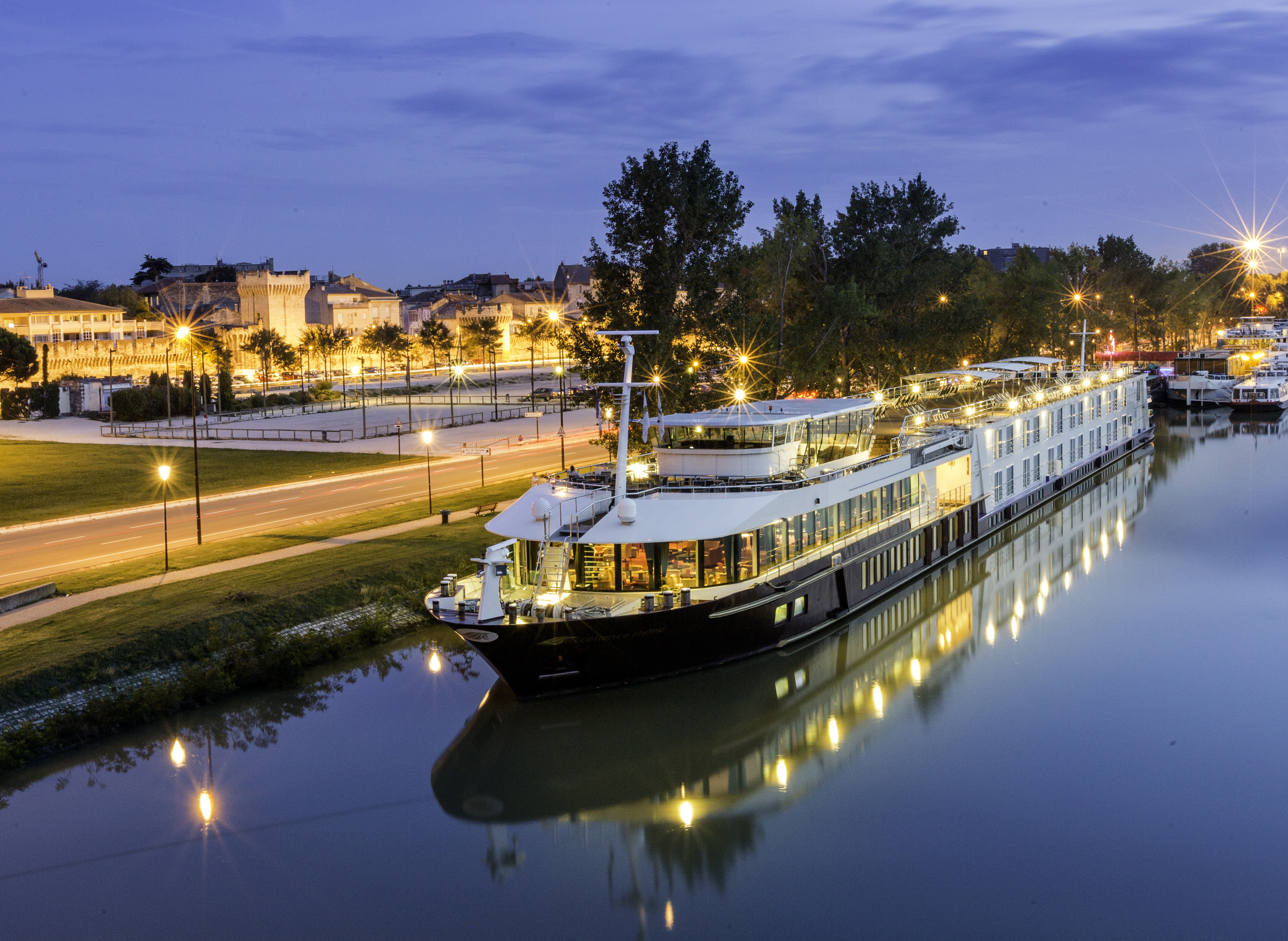 Excellence river ship sailing on the Rhône beside Avignon's illuminated historic walls