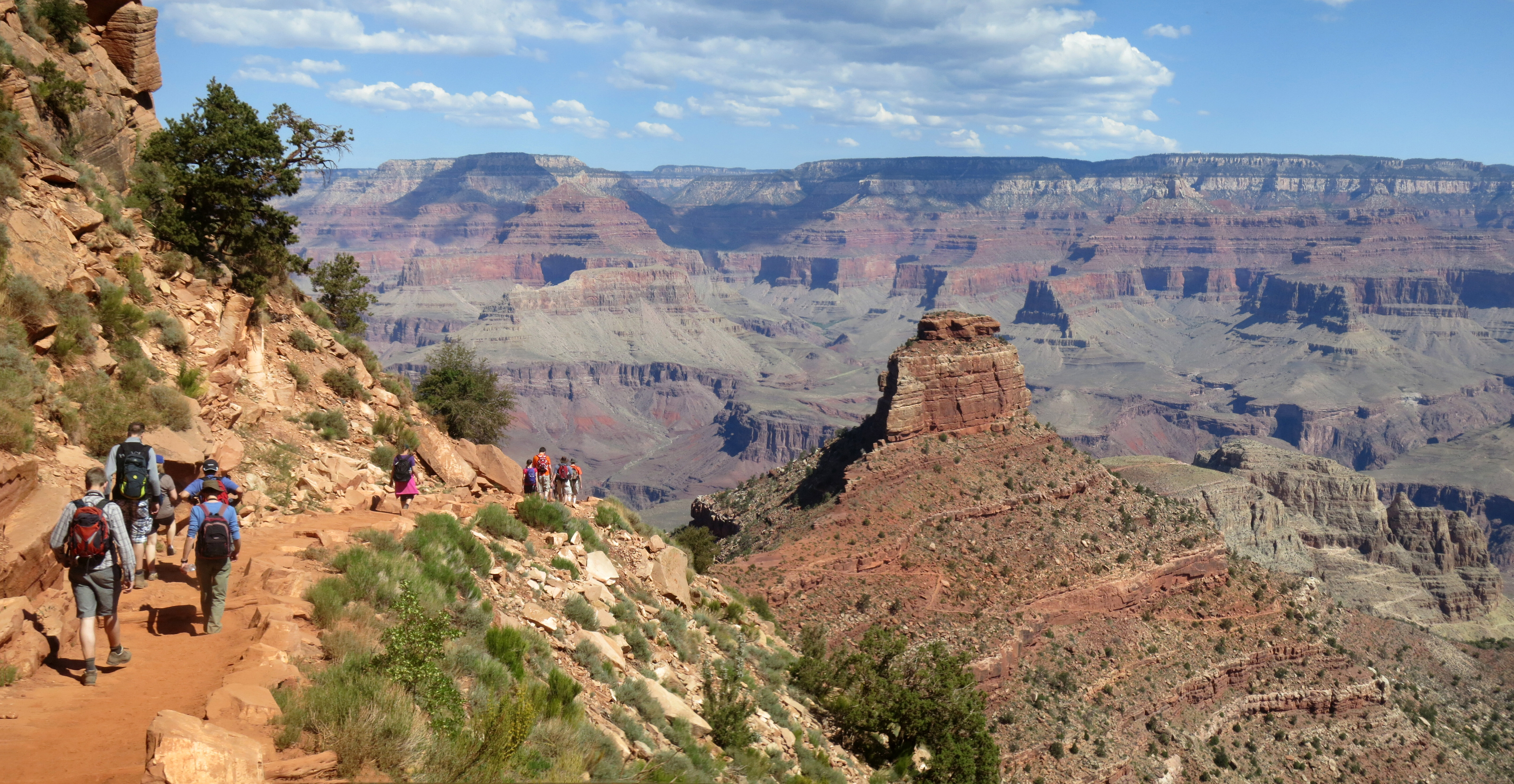 Hikers descending the South Kaibab Trail into the immense layered Grand Canyon