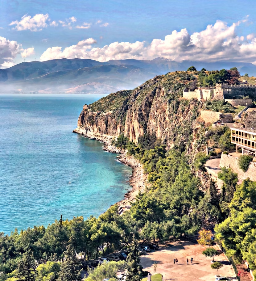 Peloponnese coastal cliffs, turquoise water, and hillside fortress in Greece