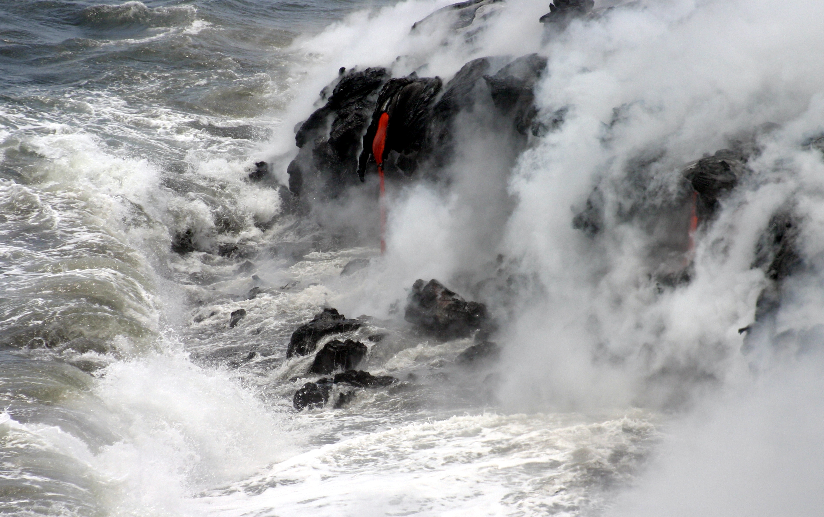 Red Kilauea lava entering the Pacific through steam on Hawaii Island