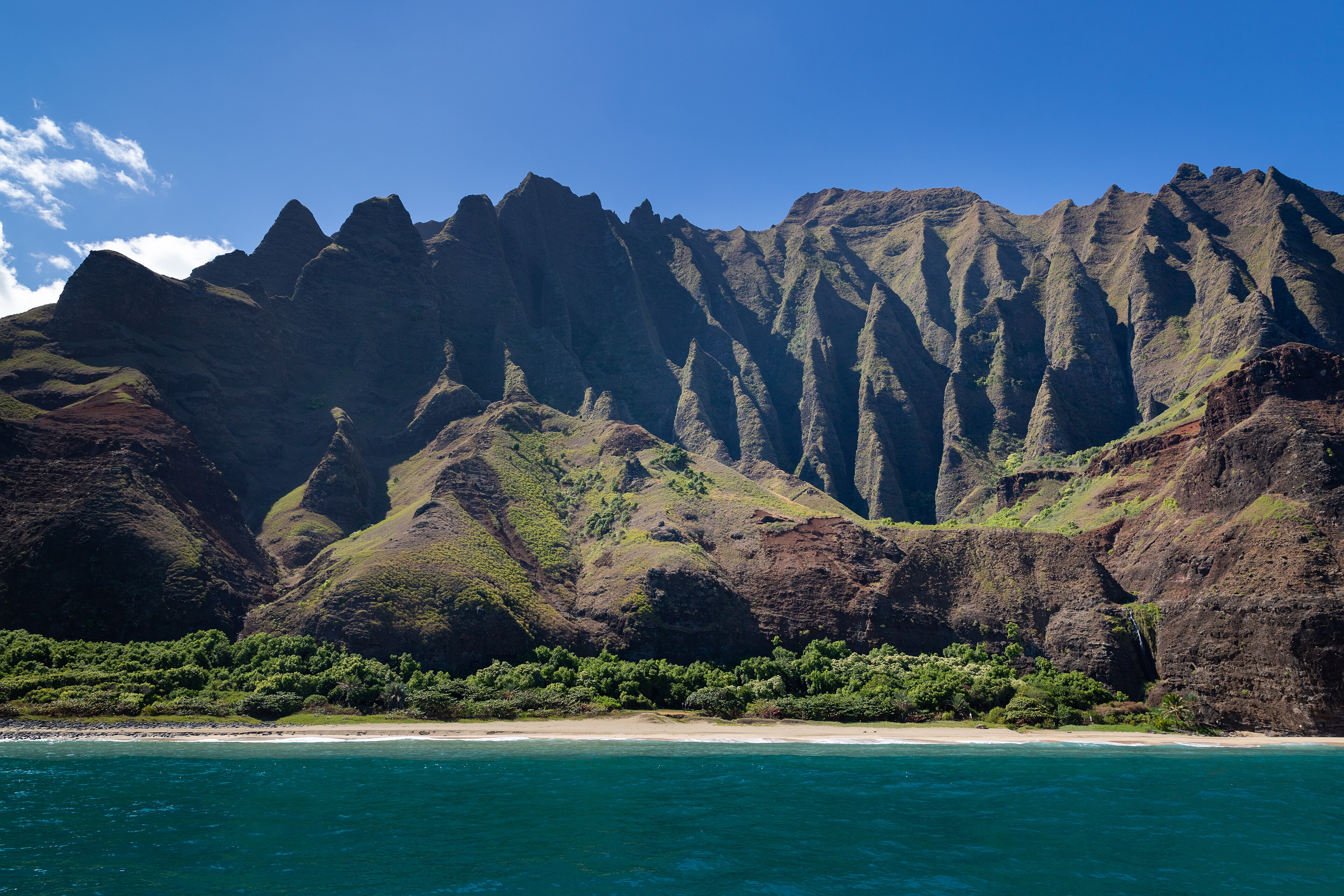 The deeply folded sea cliffs and narrow beach of the Na Pali Coast on Kauai