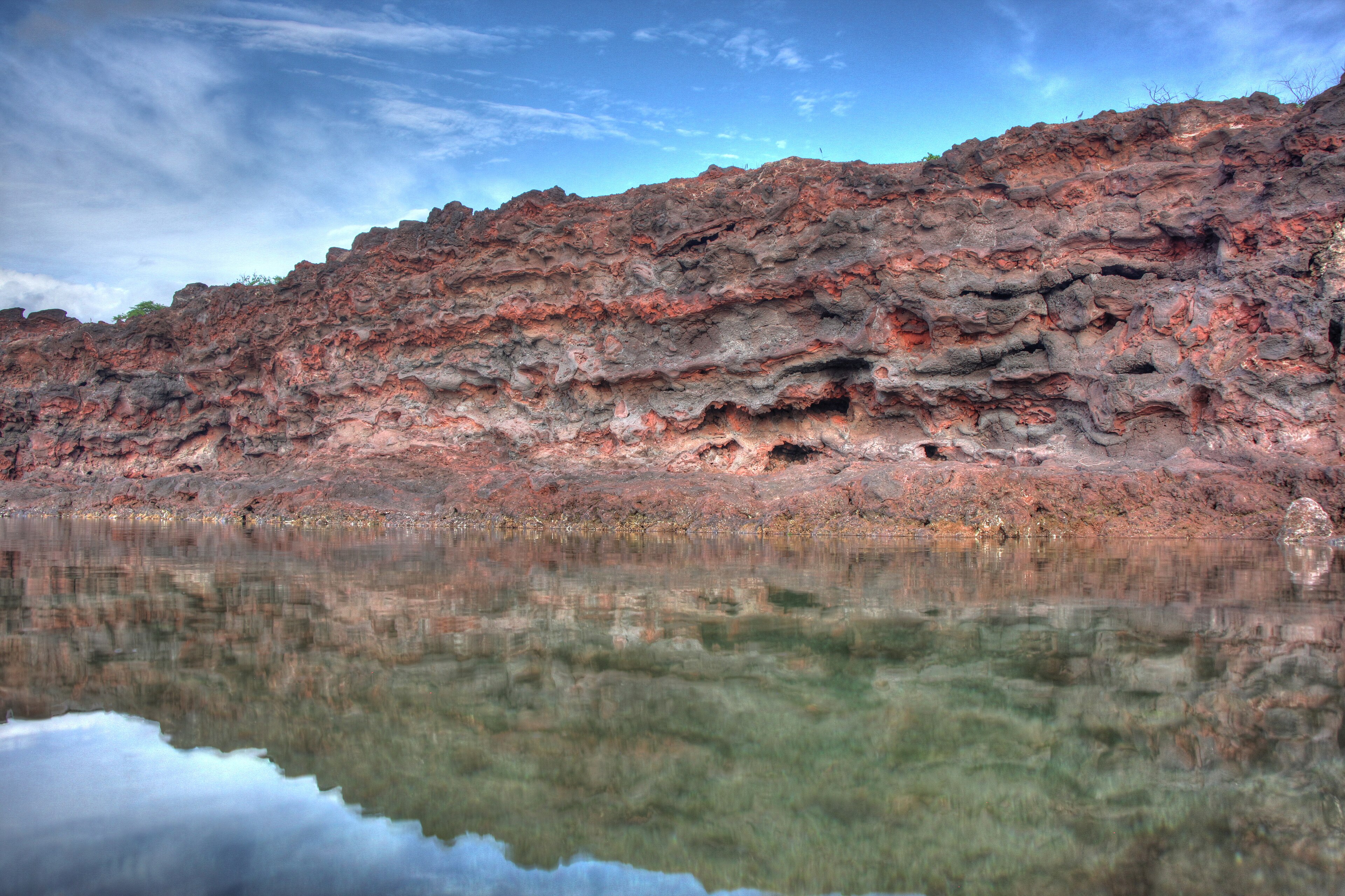 Red volcanic rock reflected in a quiet tide pool at Hulopoe Bay on Lanai