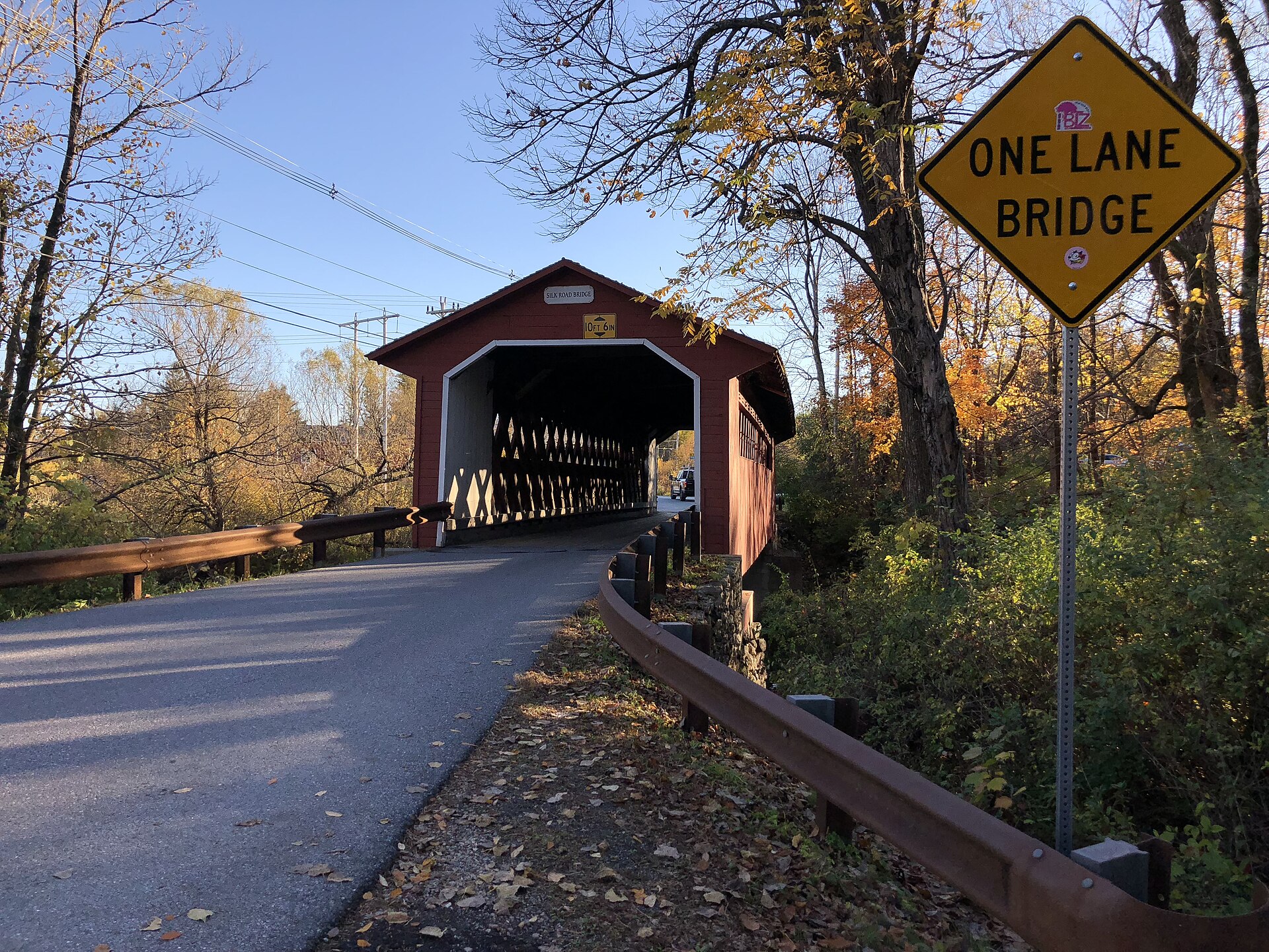 Red covered bridge spanning the Walloomsac River in autumnal Vermont