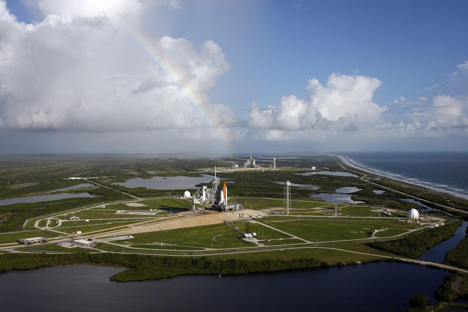 Two space shuttles on launch pads between Atlantic coast and wetlands at Kennedy Space Center