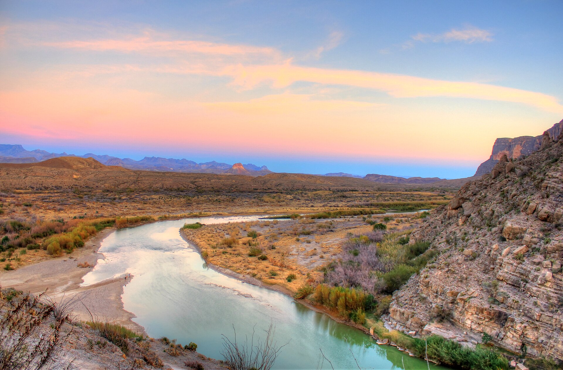 The Rio Grande emerges from Santa Elena Canyon beneath a glowing Big Bend sky