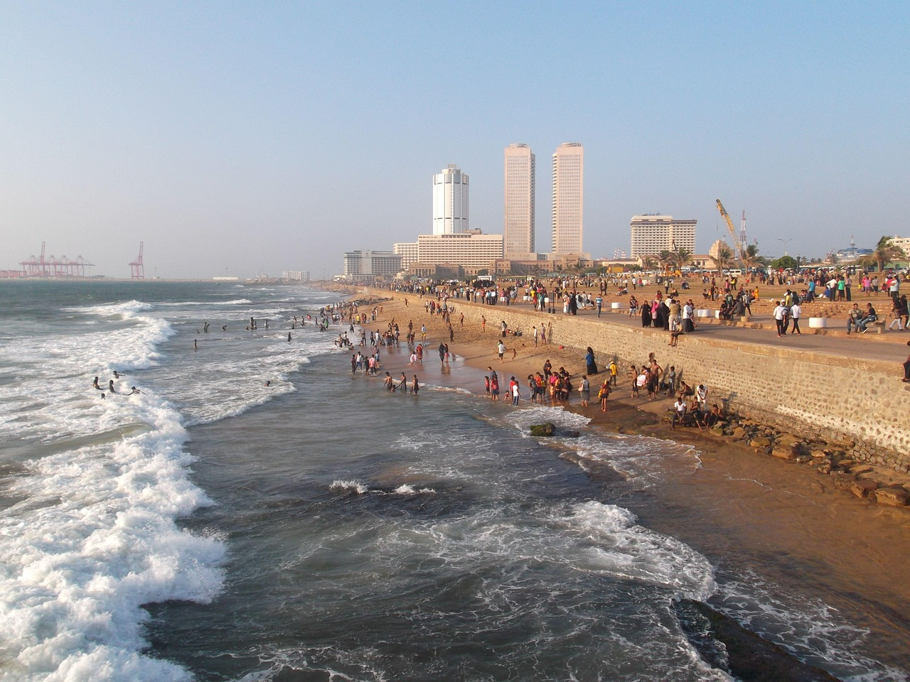Malé waterfront with local residents along the Indian Ocean shoreline and the skyline of the Maldives capital behind