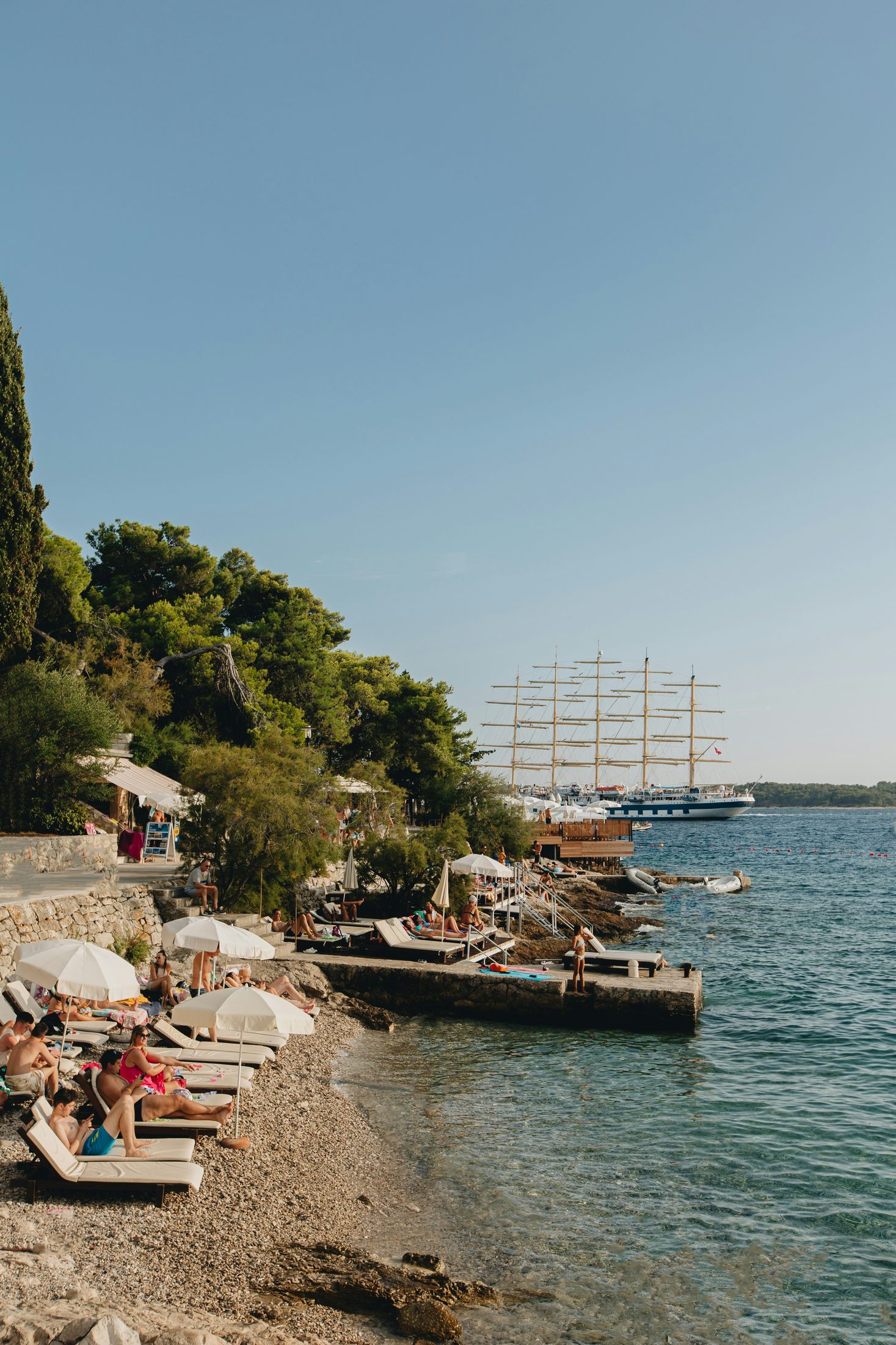 A pebble swimming cove, clear Adriatic water, and waterfront platforms on Hvar, Croatia